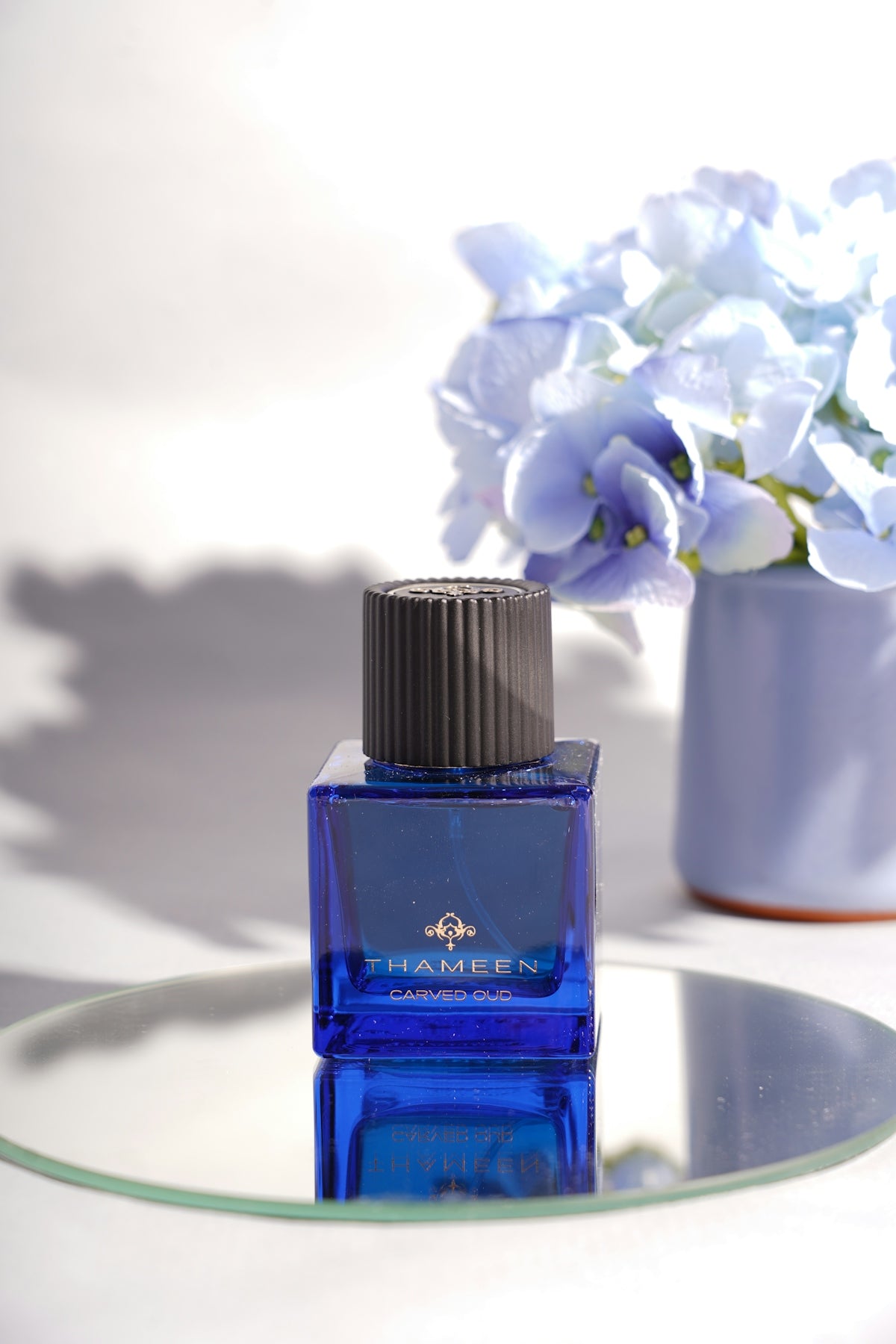 a bottle of perfume sitting on top of a glass table