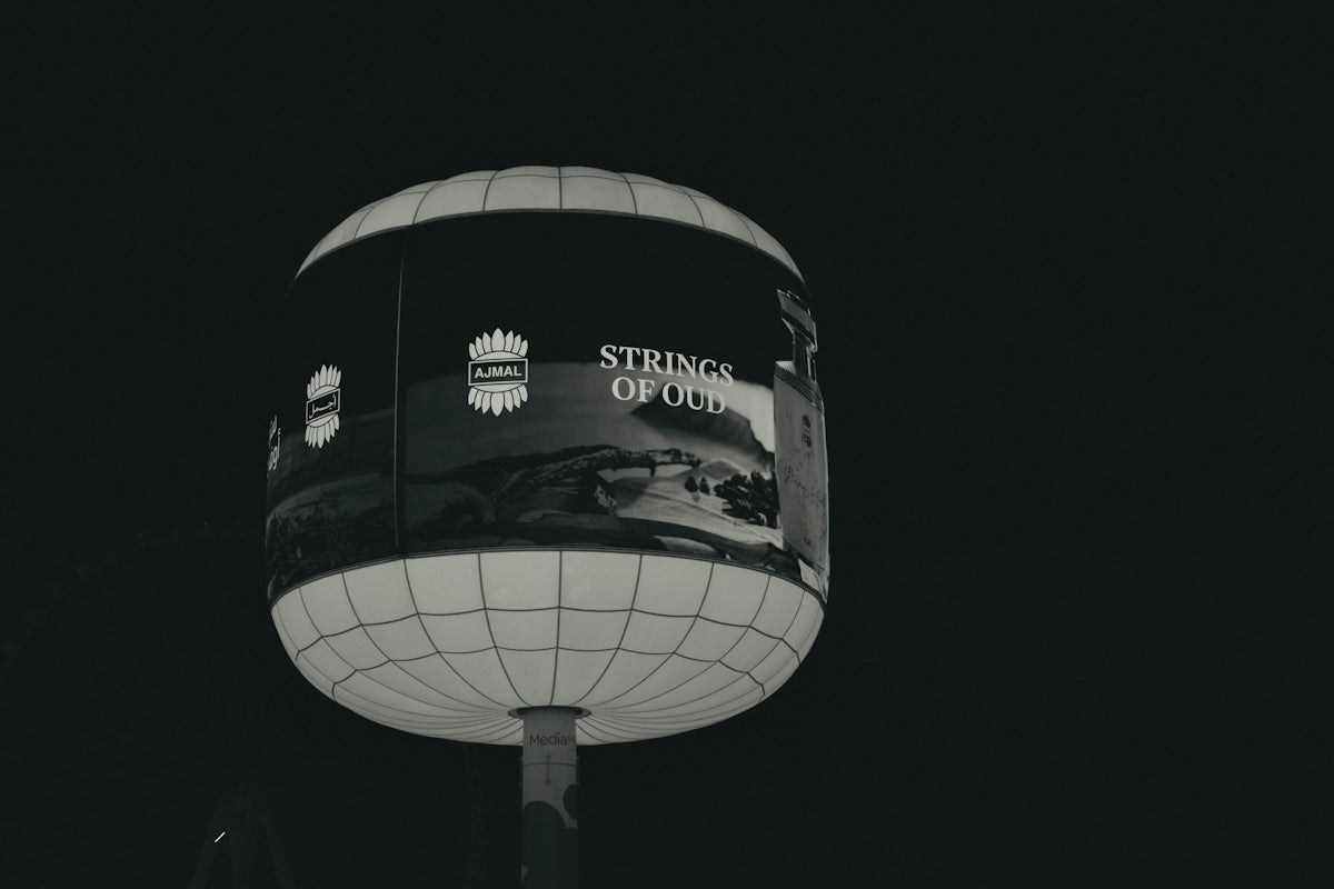 A spherical billboard advertising strings of old at night.