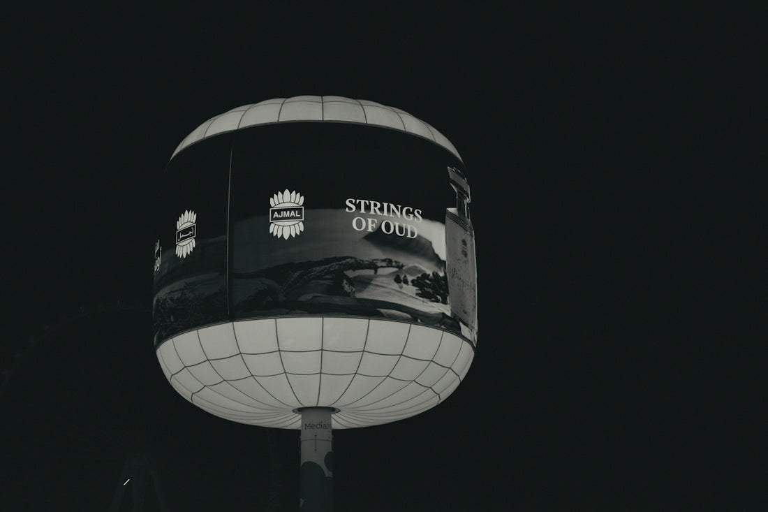 A spherical billboard advertising strings of old at night.