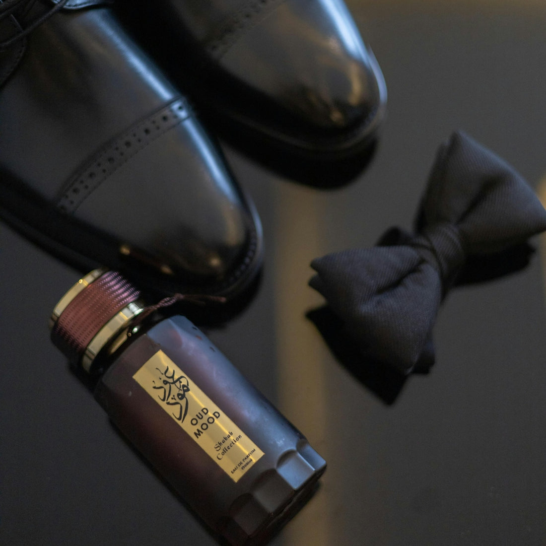 Elegant black shoes, bow tie, and perfume bottle